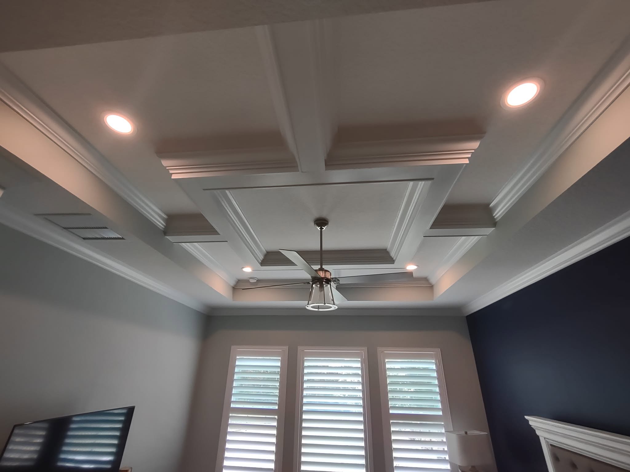 White coffered ceiling with recessed lighting and contrasting inset panels