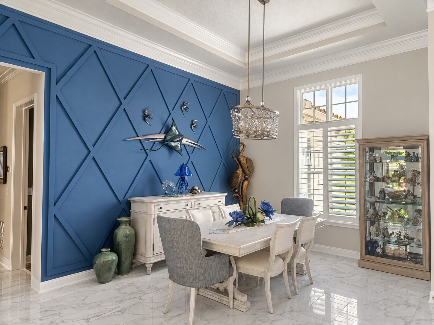 Blue geometric wall molding and white trim in a light-filled dining room