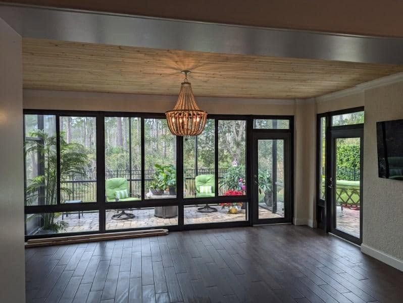 Natural wood ceiling above a sunroom with large windows